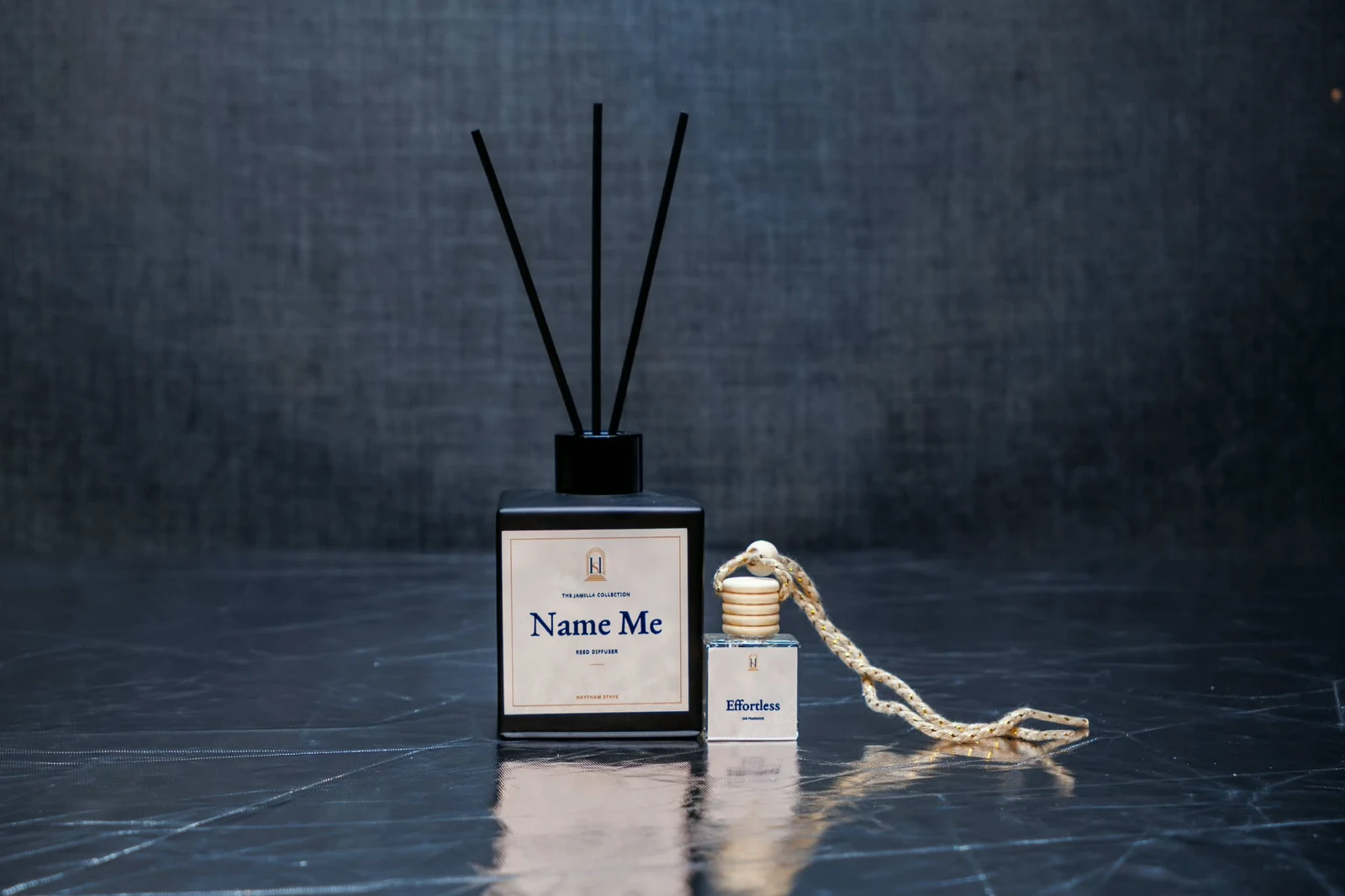 Name Me reed diffuser beside an Effortless car fragrance with a wooden cap